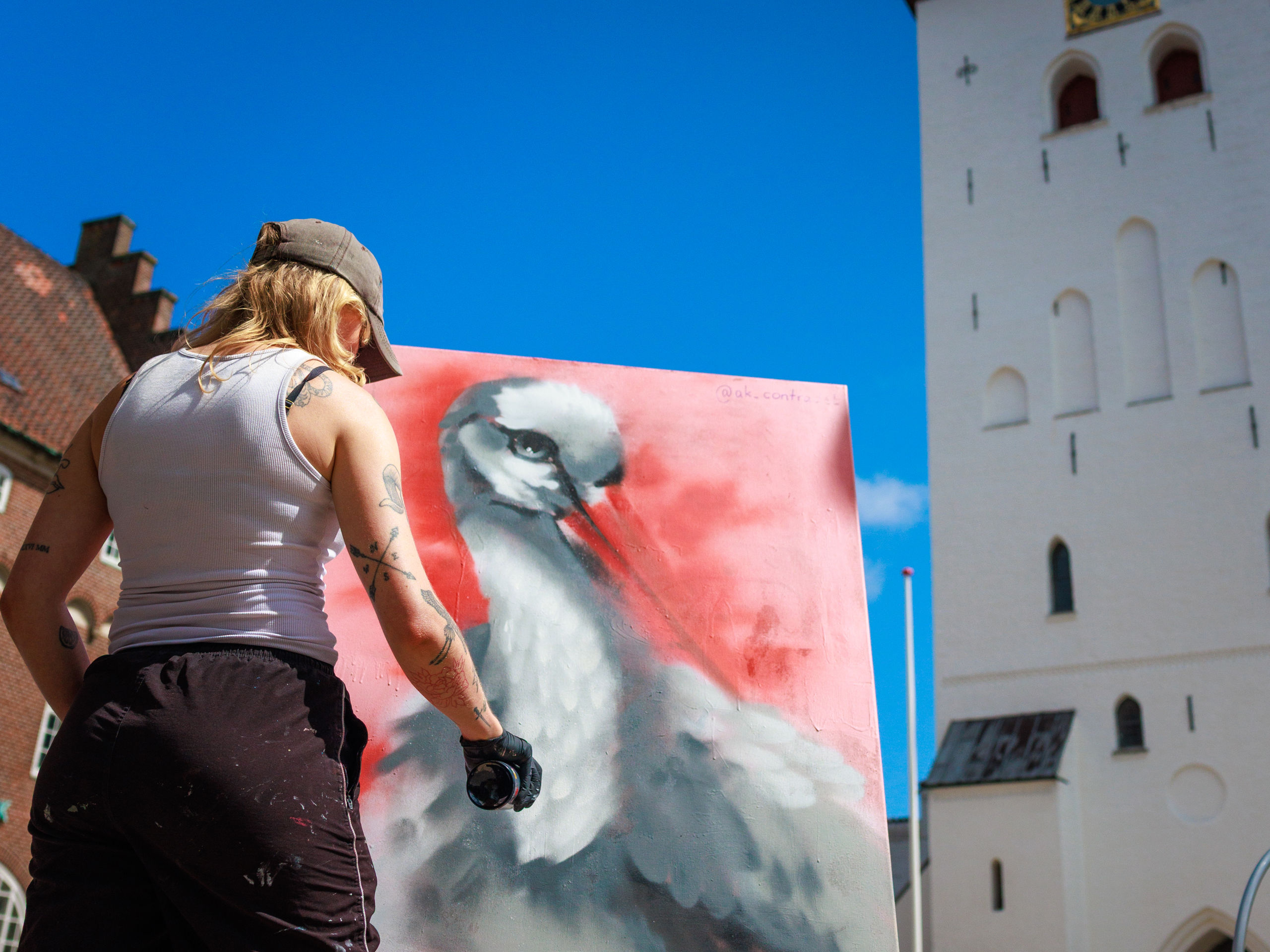 Mand, der maler et billede foran Budolfi Kirke