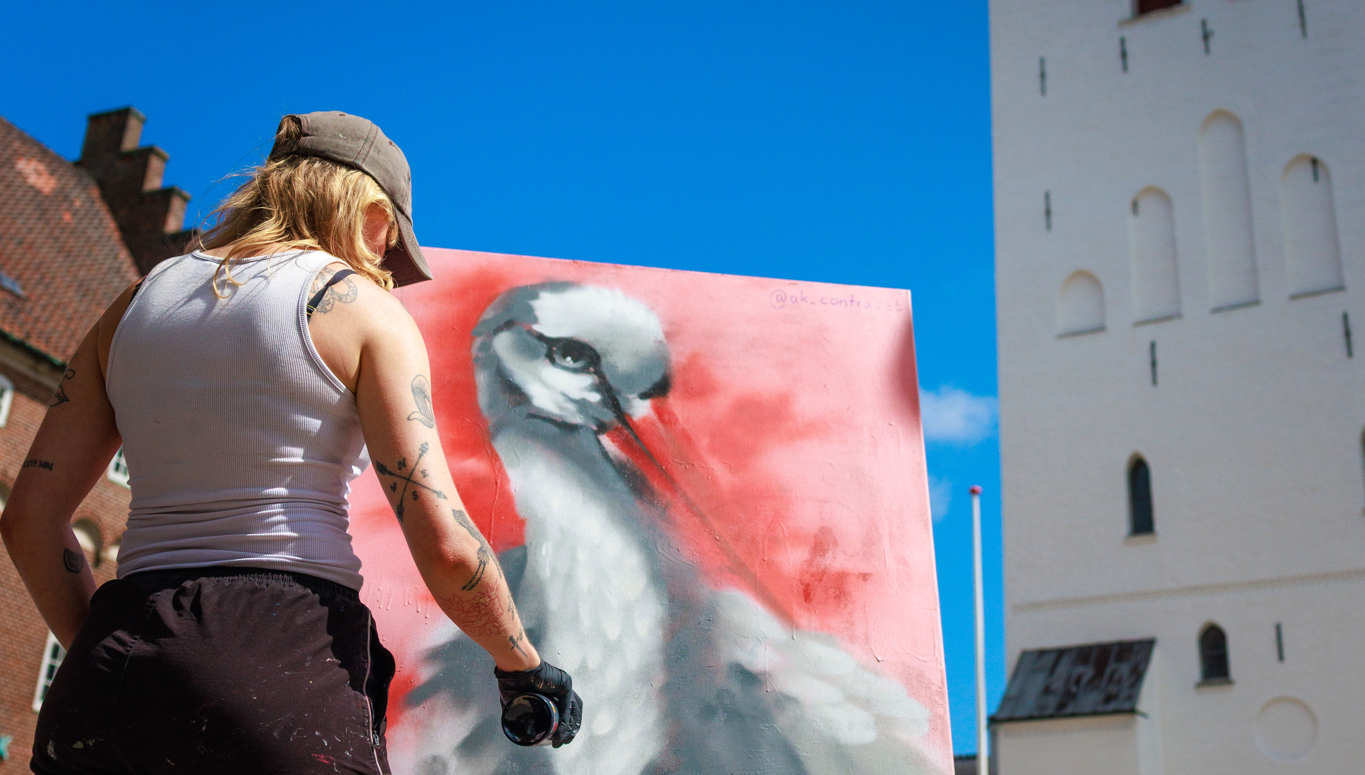 Mand, der maler et billede foran Budolfi Kirke