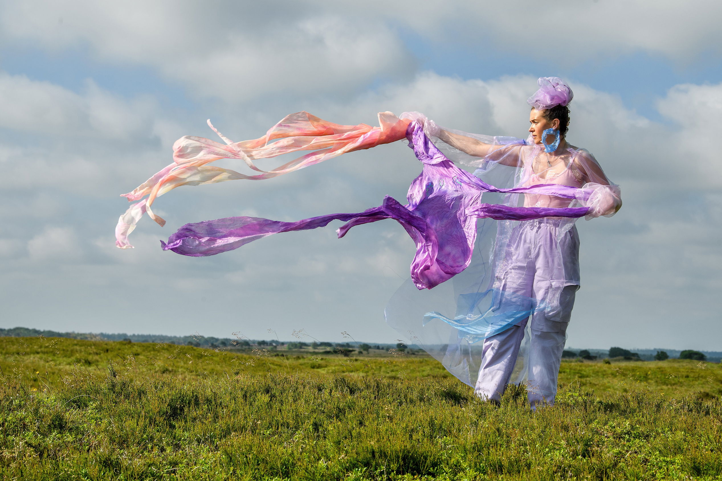 Kunstværket Walking Landscapes af Sonja Strange, der forestiller kvinde på græsmark med flyvende tørklæder.