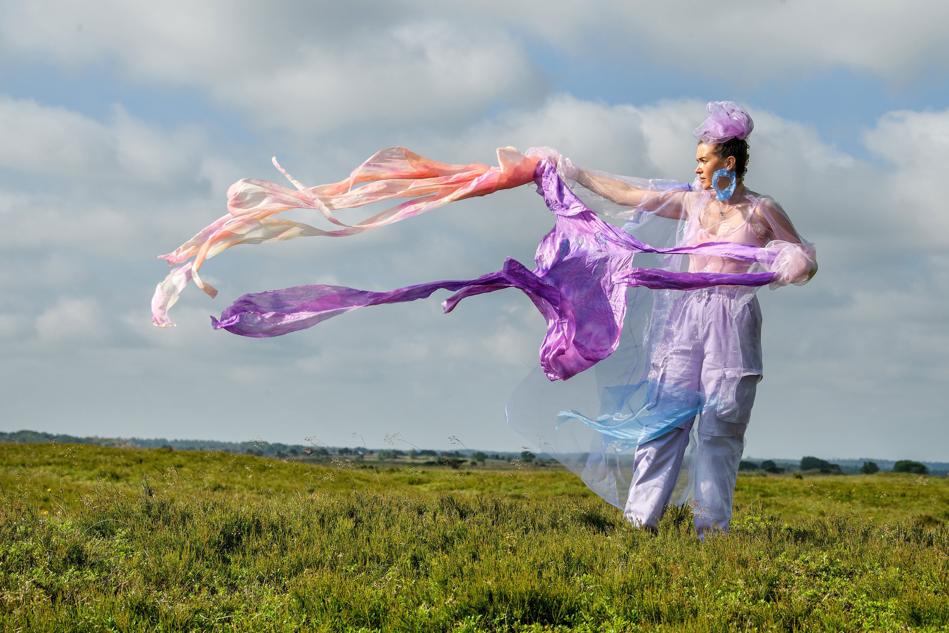 Moræne 2021 af kunstneren Sonja Strange, der forestiller kvinde på græsmark med flyvende tørklæder.